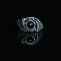 The Eclipse natural black obsidian ring with hand-shaped brass wirework, front view