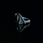 Side view of The Eclipse black obsidian ring showing its sculptural brass wirework and ringband