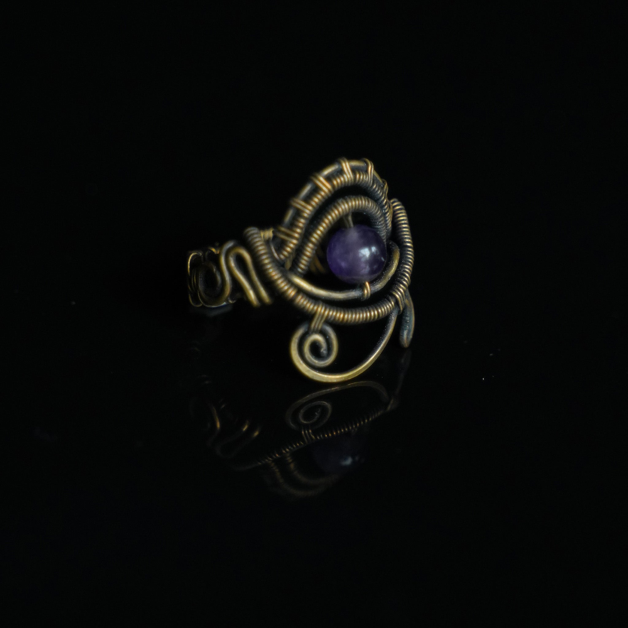 One-of-a-kind natural amethyst ring showing sculptural brass wirework