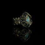 Three-quarter view of The Veil natural labradorite ring with hand-shaped brass wirework